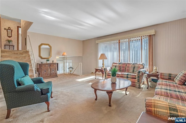 carpeted living area featuring stairs