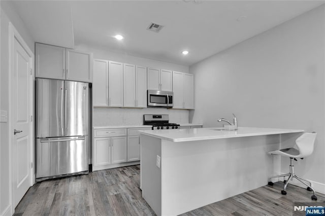 kitchen with visible vents, white cabinets, light countertops, appliances with stainless steel finishes, and light wood-type flooring