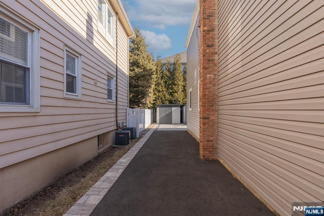 view of side of property with a patio area, fence, and cooling unit