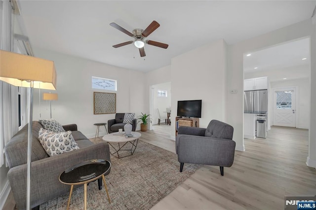 living area featuring light wood-type flooring, a ceiling fan, and recessed lighting