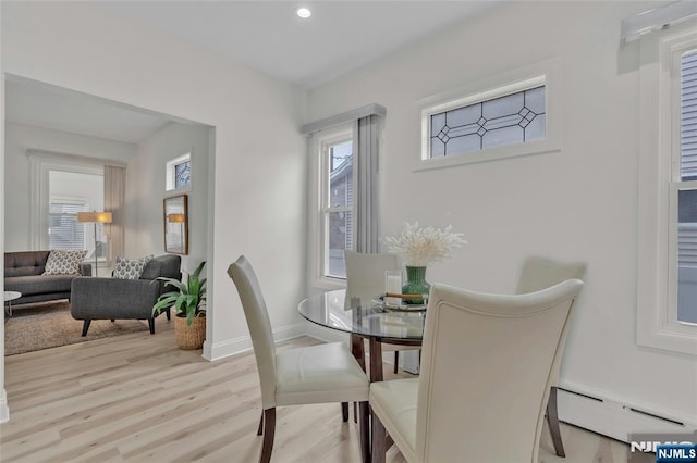 dining area with light wood finished floors, baseboard heating, plenty of natural light, and recessed lighting