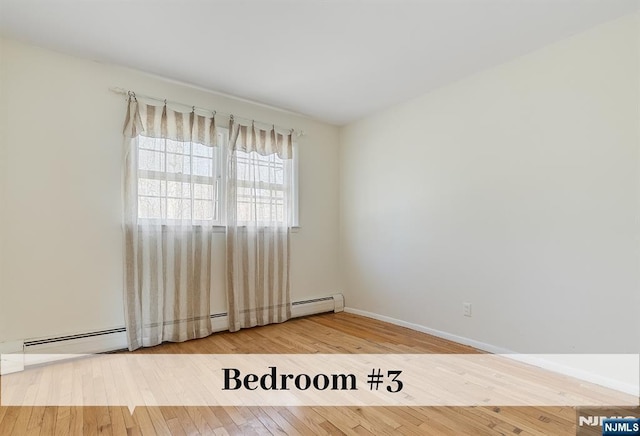 empty room with baseboards and hardwood / wood-style floors