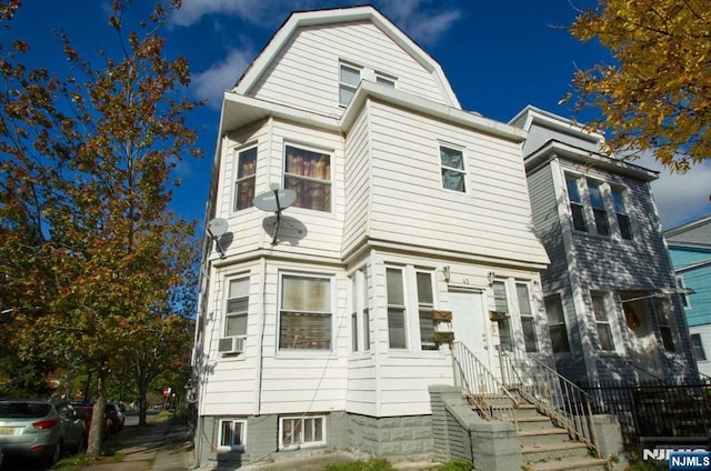 view of front of home with cooling unit and a gambrel roof