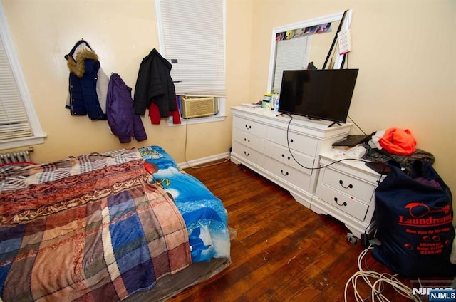 bedroom with dark wood-type flooring, cooling unit, and baseboards