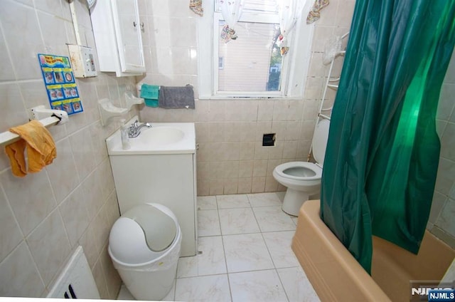 full bath with marble finish floor, tile walls, shower / bathtub combination with curtain, toilet, and vanity