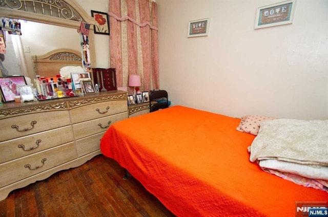 bedroom with dark wood-style flooring