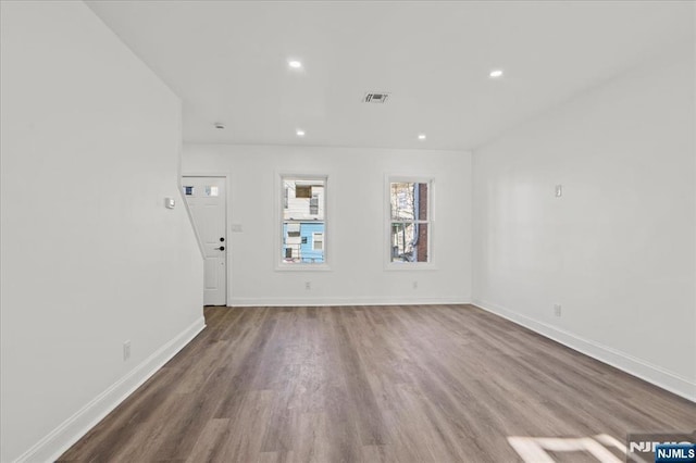 unfurnished living room featuring baseboards, wood finished floors, and recessed lighting