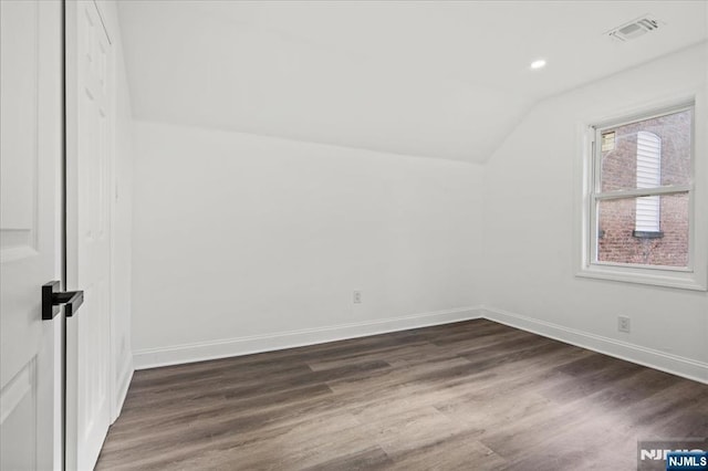 bonus room with lofted ceiling, recessed lighting, visible vents, dark wood-type flooring, and baseboards