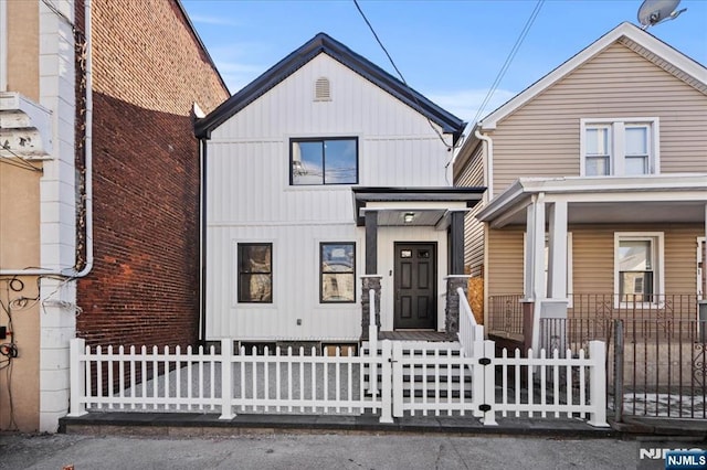 view of front of home with a fenced front yard and board and batten siding