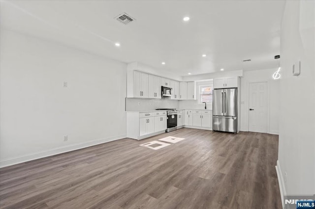 kitchen with visible vents, appliances with stainless steel finishes, wood finished floors, light countertops, and white cabinetry