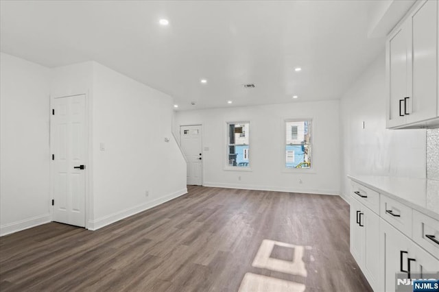 unfurnished living room with recessed lighting, baseboards, and wood finished floors