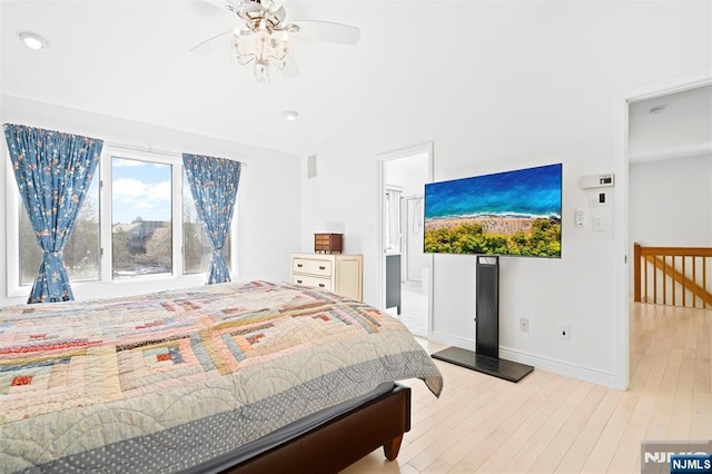 bedroom featuring lofted ceiling, baseboards, and wood finished floors