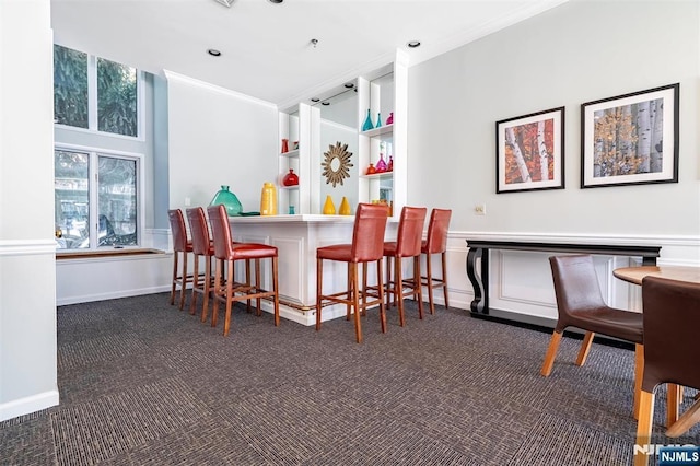 bar featuring a dry bar, recessed lighting, dark carpet, ornamental molding, and baseboards