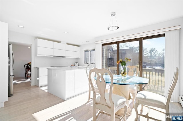 dining space with recessed lighting and light wood-style flooring