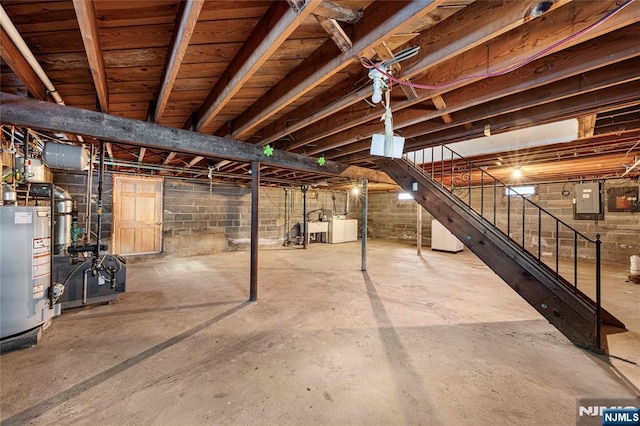 unfinished basement with water heater, stairway, electric panel, a heating unit, and washing machine and clothes dryer