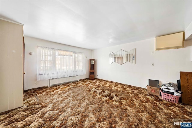 unfurnished living room featuring carpet floors and radiator