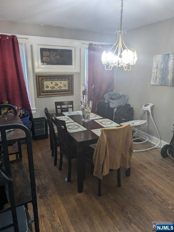 dining room featuring baseboards, a chandelier, and dark wood finished floors