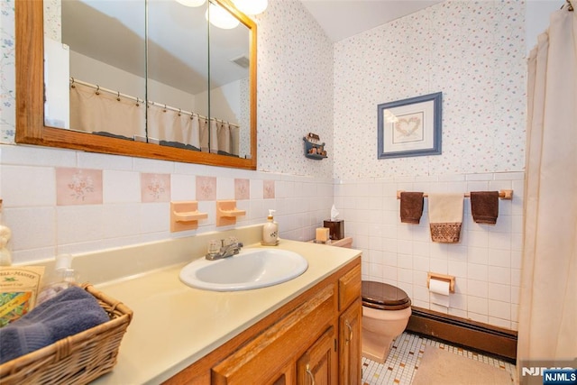 full bathroom featuring baseboard heating, toilet, wallpapered walls, and a wainscoted wall