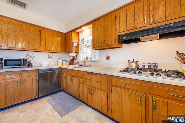 kitchen featuring visible vents, under cabinet range hood, a sink, appliances with stainless steel finishes, and light countertops