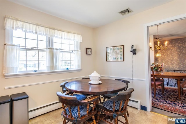 dining area with visible vents, baseboard heating, and a chandelier