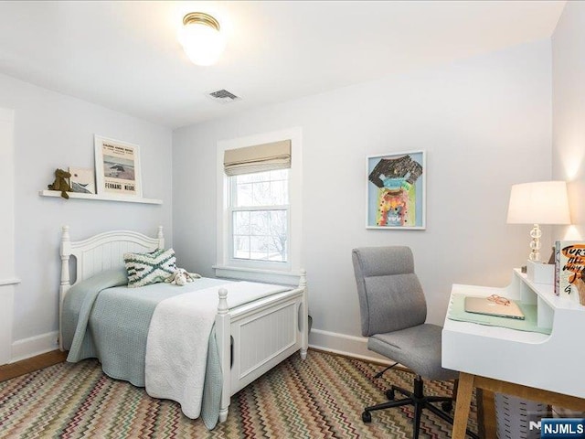 bedroom featuring baseboards and visible vents