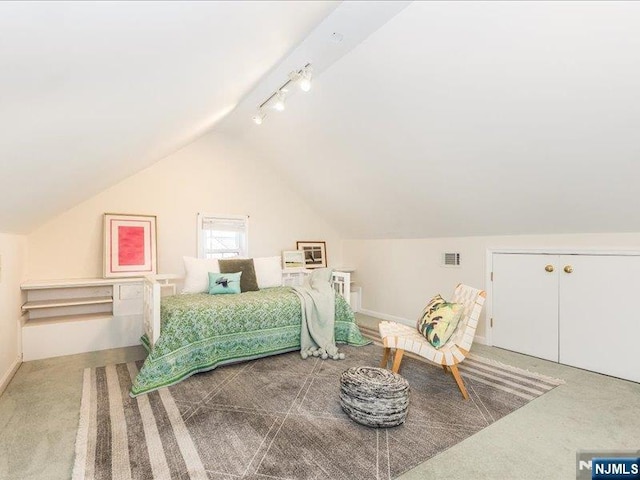 bedroom with carpet floors, lofted ceiling, visible vents, track lighting, and baseboards