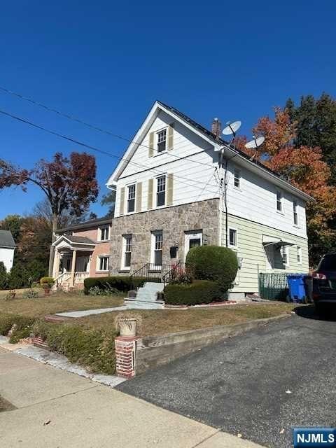 view of front of home with stone siding and a chimney