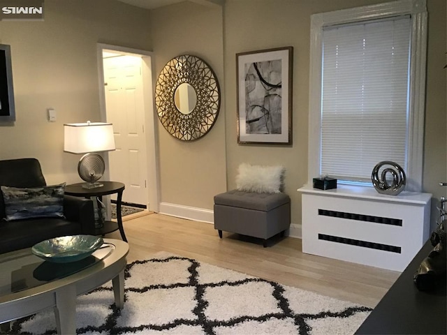 living area featuring light wood-style floors and baseboards