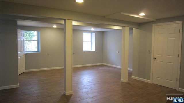 basement with baseboards, dark wood finished floors, and recessed lighting