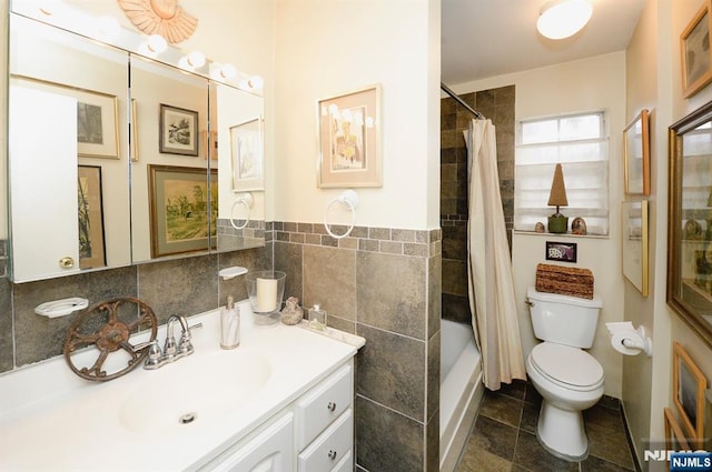 full bathroom featuring tile patterned flooring, toilet, vanity, tile walls, and shower / bath combo with shower curtain