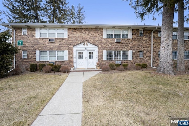 townhome / multi-family property featuring brick siding and a front yard