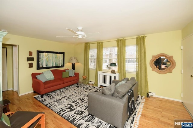 living room with baseboards, a ceiling fan, radiator, baseboard heating, and light wood-style floors