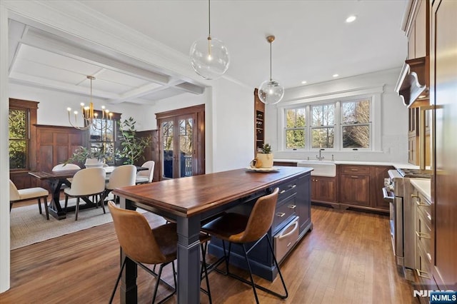 dining room with coffered ceiling, wood finished floors, beam ceiling, and a healthy amount of sunlight