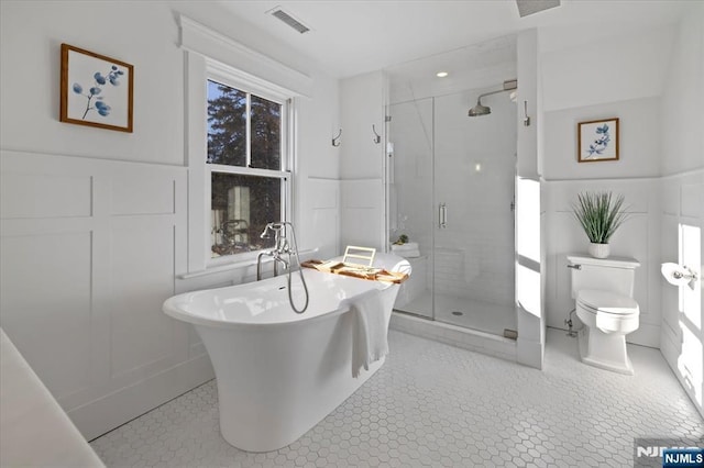 bathroom with toilet, visible vents, a freestanding bath, tile patterned floors, and a stall shower