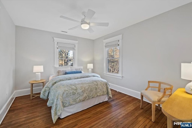 bedroom featuring dark wood-style flooring, multiple windows, visible vents, and baseboards