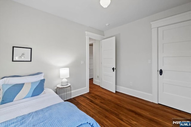 bedroom with baseboards and dark wood-style flooring