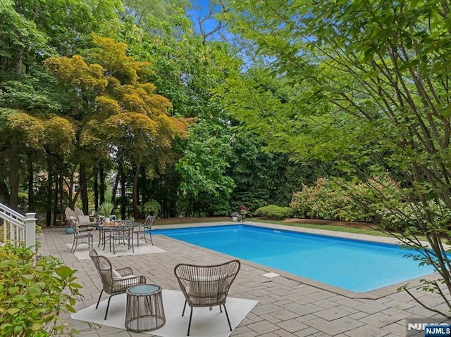 outdoor pool with a patio area