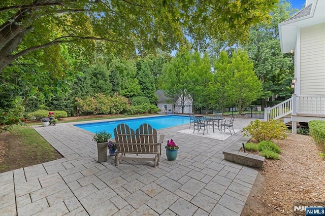 outdoor pool featuring a patio and fence