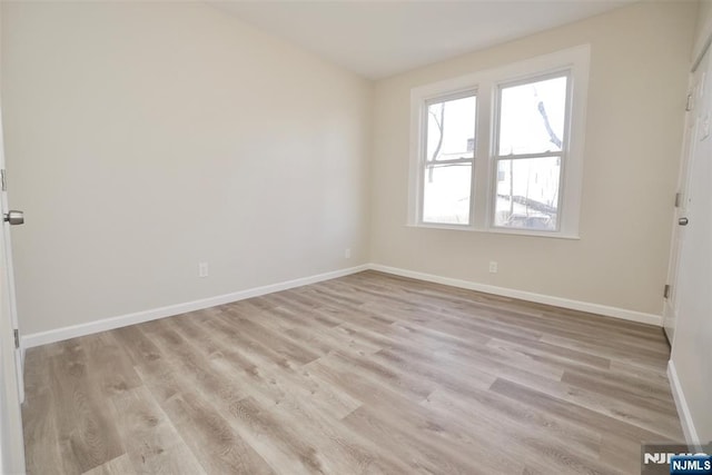 unfurnished room featuring wood finished floors and baseboards