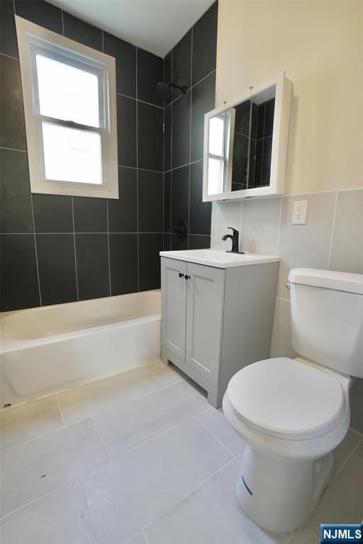 bathroom featuring washtub / shower combination, tile patterned flooring, vanity, and toilet