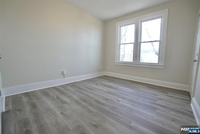 empty room featuring baseboards and wood finished floors