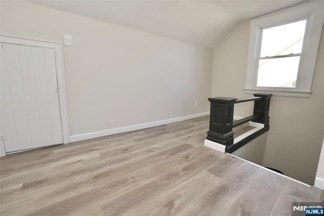 bonus room with vaulted ceiling, wood finished floors, and baseboards