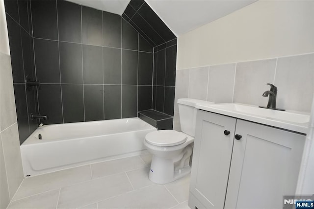 full bath featuring bathing tub / shower combination, tile walls, toilet, vanity, and tile patterned floors