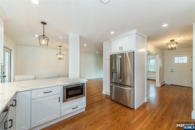 kitchen featuring stainless steel fridge with ice dispenser, built in microwave, baseboard heating, light wood-type flooring, and recessed lighting