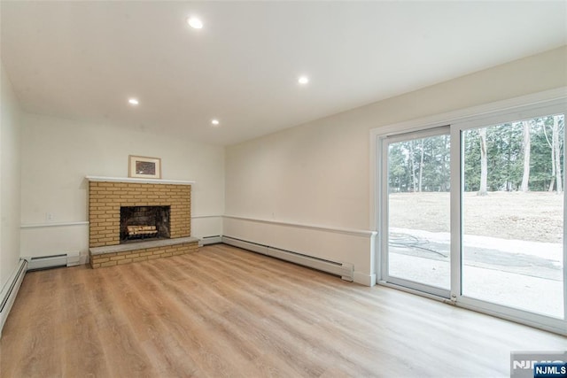 unfurnished living room featuring a baseboard heating unit, a fireplace, wood finished floors, and recessed lighting