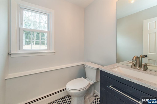 bathroom featuring a baseboard heating unit, vanity, and toilet