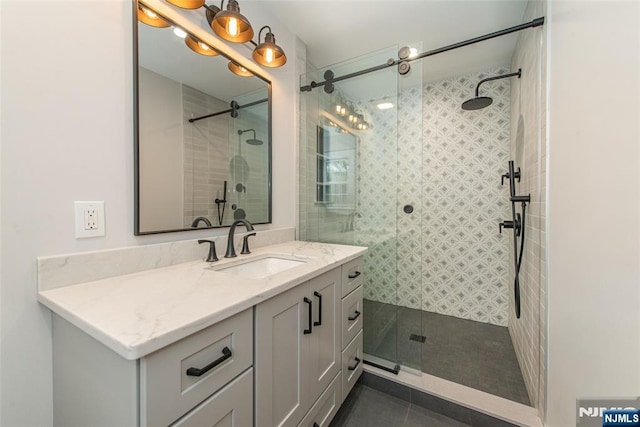 bathroom with a stall shower, tile patterned flooring, and vanity