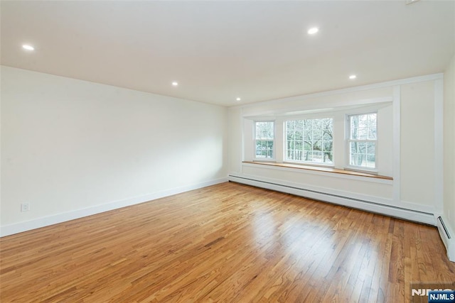 spare room featuring recessed lighting, baseboards, light wood finished floors, and baseboard heating