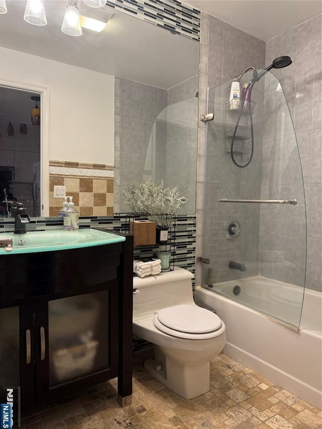 full bathroom featuring toilet, shower / washtub combination, tile walls, and vanity