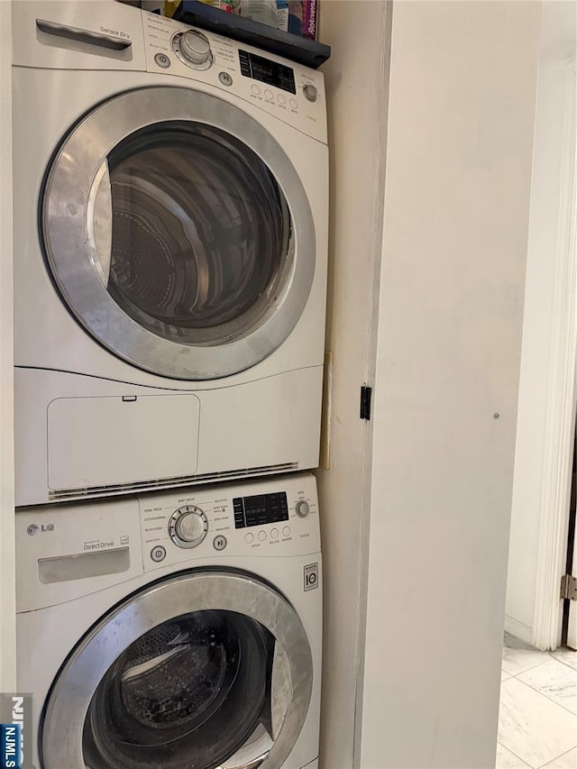 laundry area with marble finish floor, laundry area, and stacked washing maching and dryer